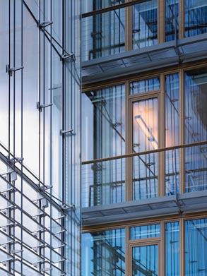 Photo:Three types of facades meet in one point: The cable net façade of the atrium, the insulating double-skin façade and the wood-framed timber glass façade facing the winter garden.